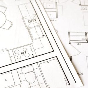 Close-up view of an architectural floor plan on paper showcasing detailed room layouts and measurements.